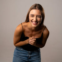 Thumbnail for Smiling woman in black top showcasing joy and happiness, perfect for promoting the Drop Photo Necklace by Brother & Sisters.
