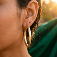 Thumbnail for Diamond Cut Statement Hoops in Gold, close-up on the earlobe | SKU: 41009-gold