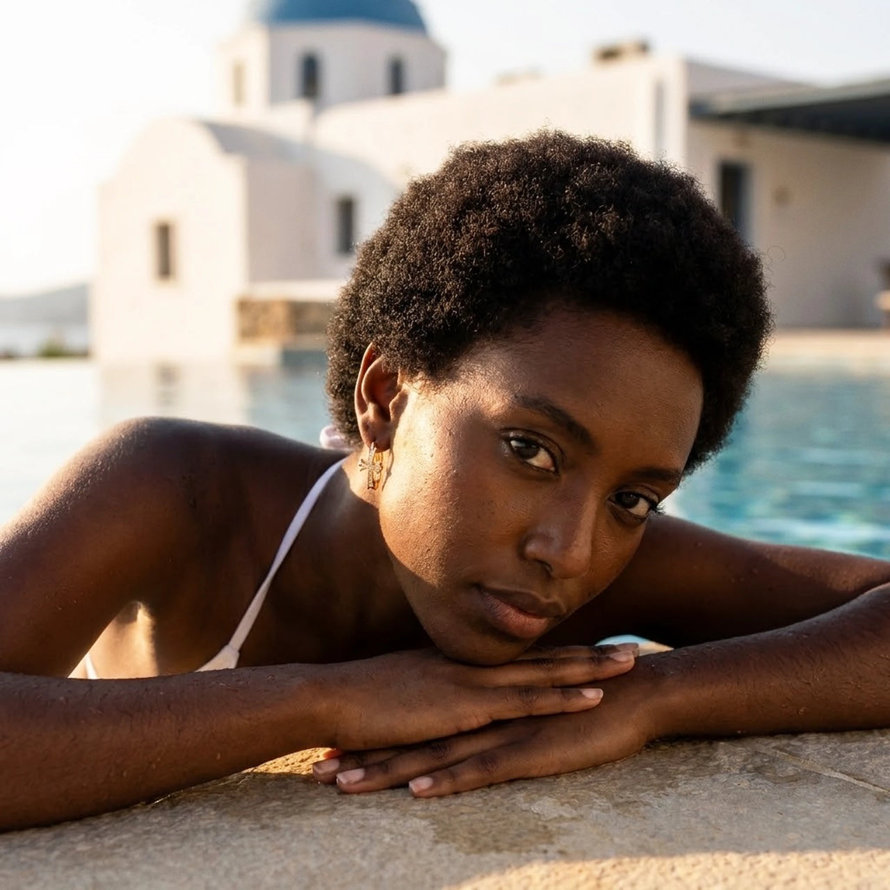 Pave Cross Huggie Hoops in Gold, worn by a pool in Santorini | SKU: 41006-gold