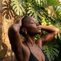 Thumbnail for Pave Cross Huggie Hoops in Gold, worn in a tropical outdoor shower | SKU: 41006-gold