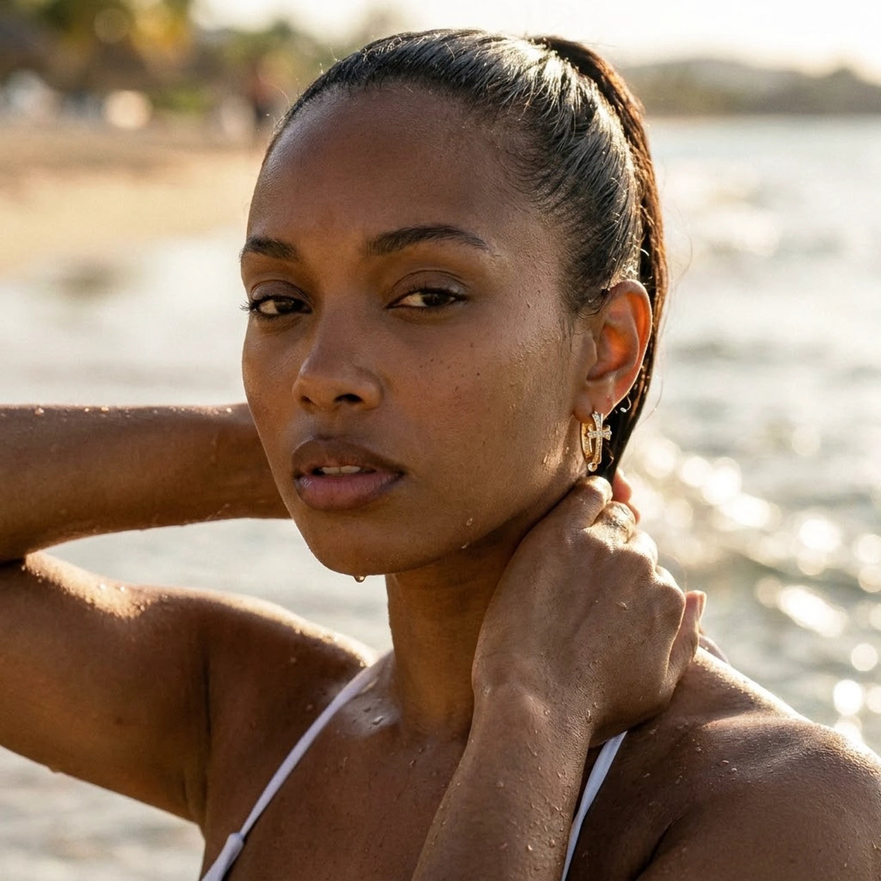 Pave Cross Huggie Hoops in Gold, worn in the sea, wet skin | SKU: 41006-gold