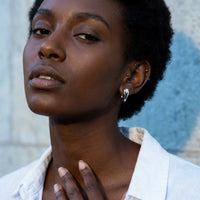 Thumbnail for Pear Crystal Huggie Hoops in Silver, worn, close-up | SKU: 41007-silver