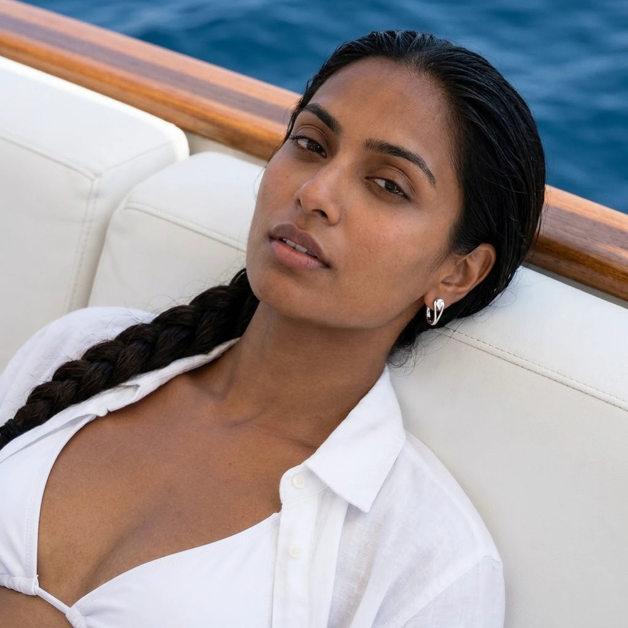 Pear Crystal Huggie Hoops in Silver, worn on a yacht | SKU: 41007-silver