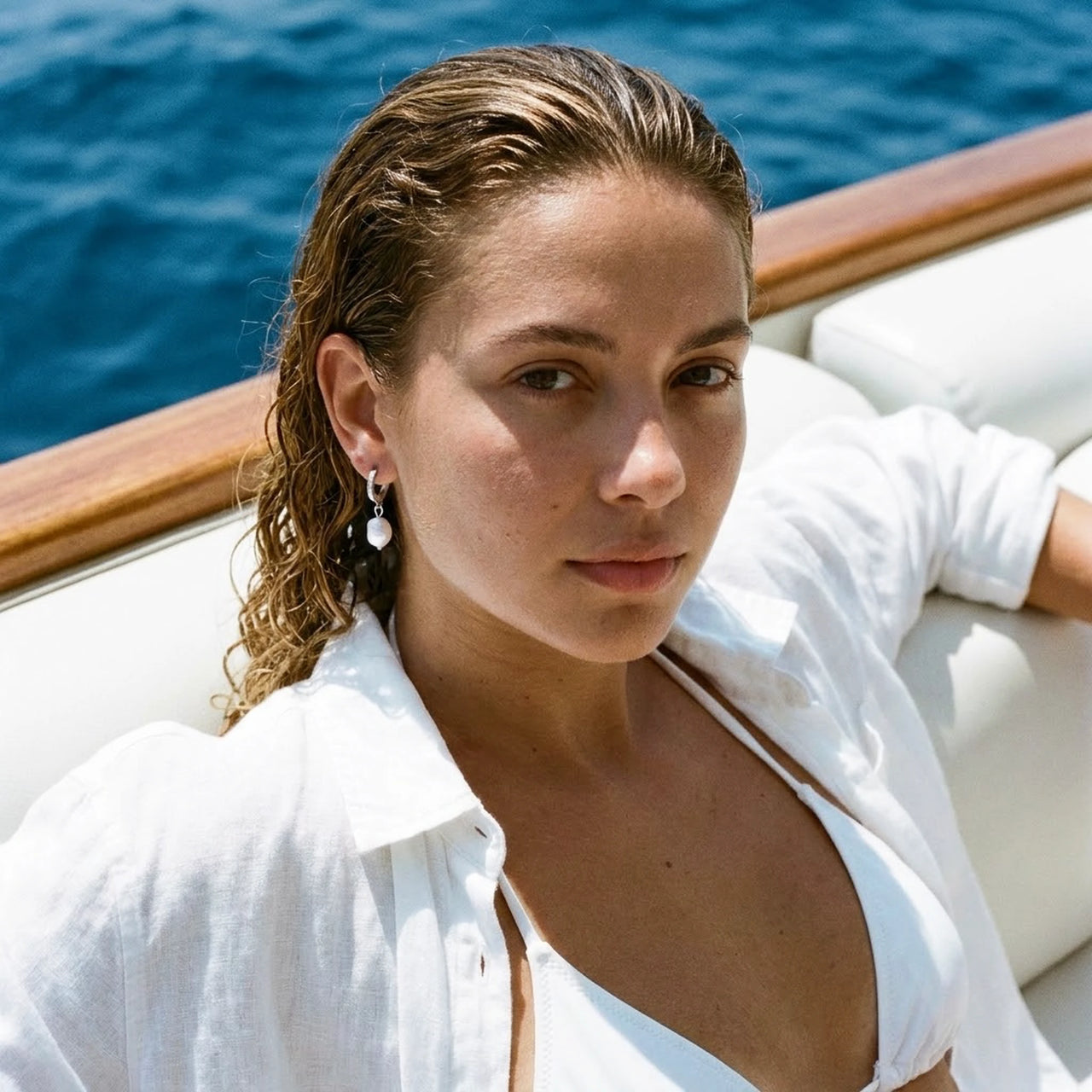 Pearl Drop Huggie Hoops in Silver, worn on a yacht | SKU: 41003-silver