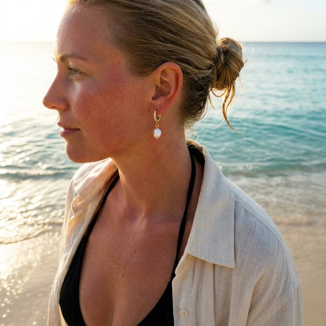 Pearl Drop Huggie Hoops in Silver, worn on the beach | SKU: 41003-silver