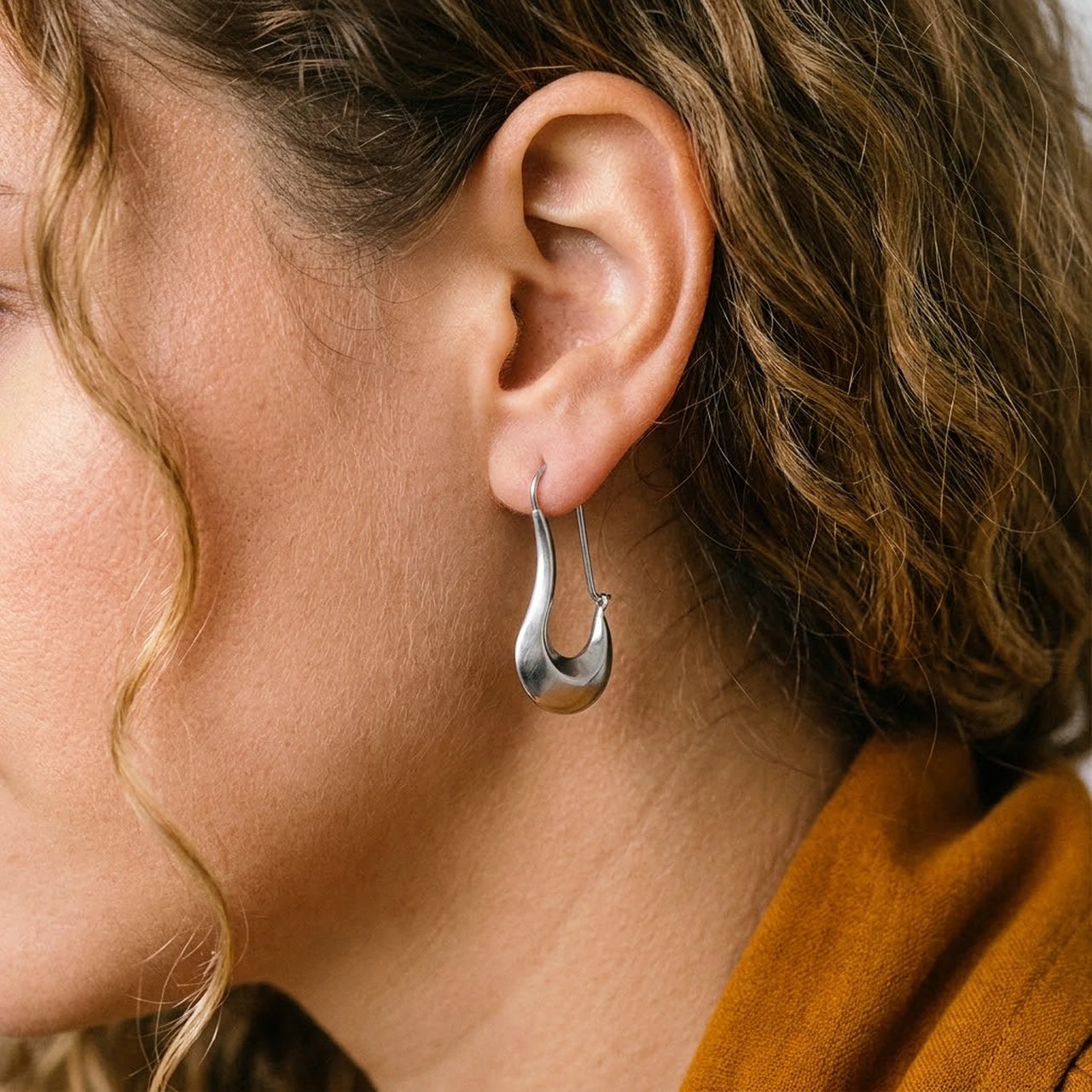 Sculpted Crescent Drops in Silver, close-up on the earlobe | SKU: 41008-silver