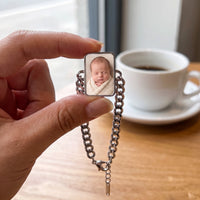 Thumbnail for The silver cushion-cut photo charm held between two fingers, showing its real small size with a newborn baby's photo | SKU: TPH-CUSB-SILVER