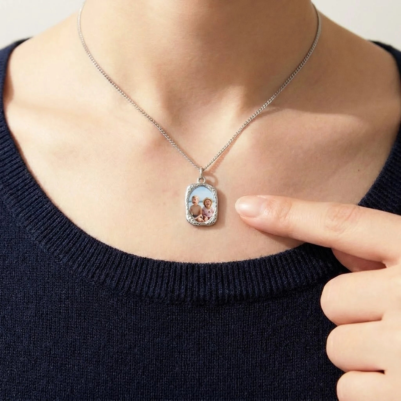 Looking down at the silver oval pendant, real small size, her children's photo inside | SKU: TPH-OVLN-SILVER