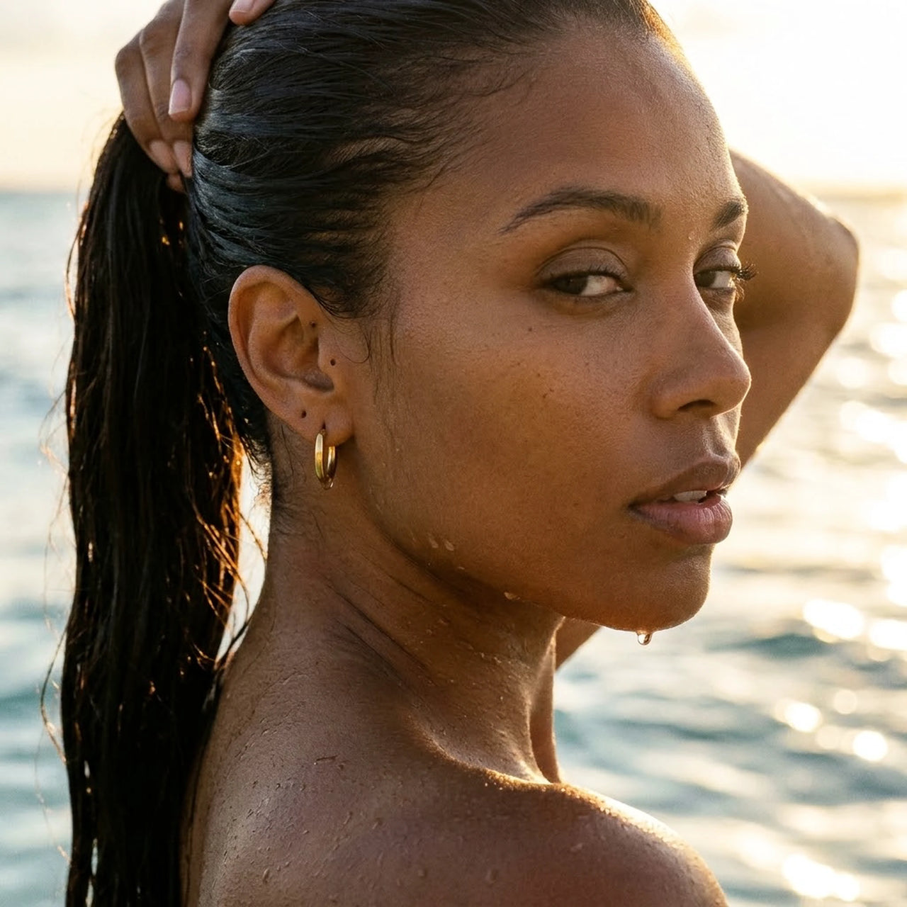 Tiny Huggie Hoops in Gold, worn in the sea, wet skin | SKU: 41002-gold