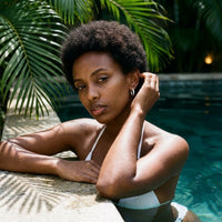 Thumbnail for Twisted Rope Huggie Hoops in Silver, worn by a tropical pool | SKU: 41012-silver